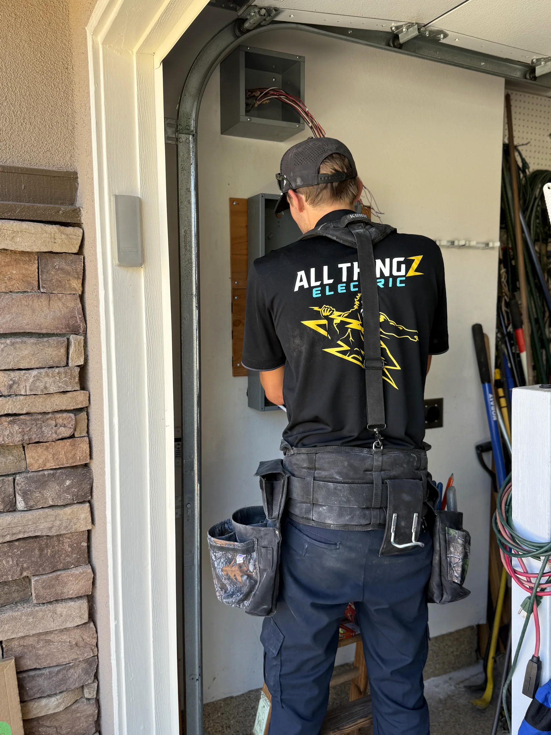All Thingz Electric technician working on a residential sub-panel in a South Orange County garage